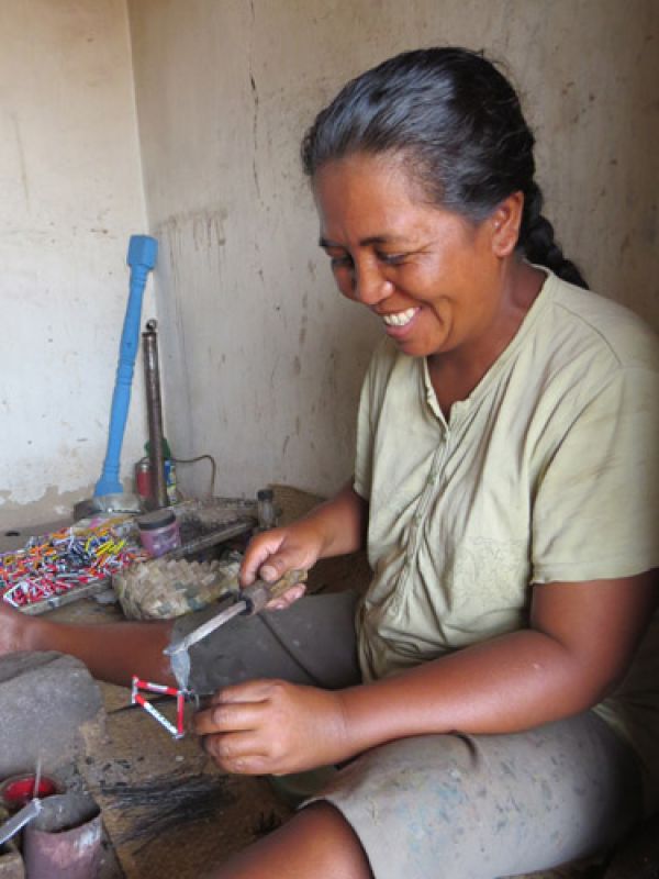 4. Mme Vohirana is assembling components by soldering. The soldering iron is heated on the hot coal.